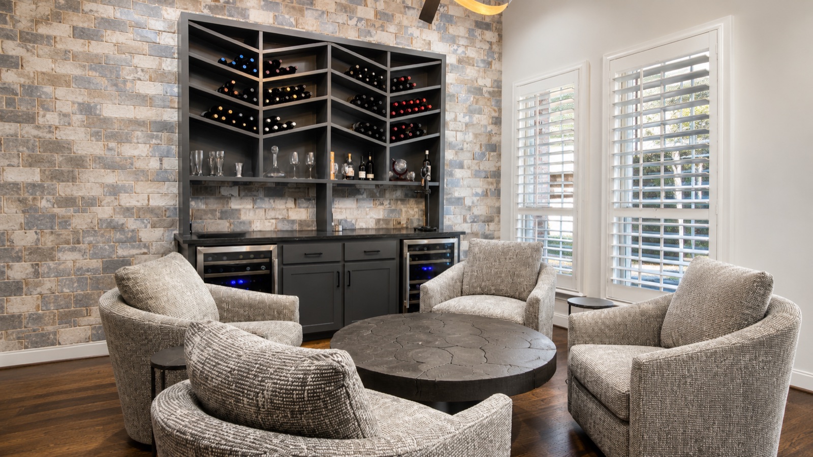 Seating area with wine storage, textured chairs, and stone accent wall