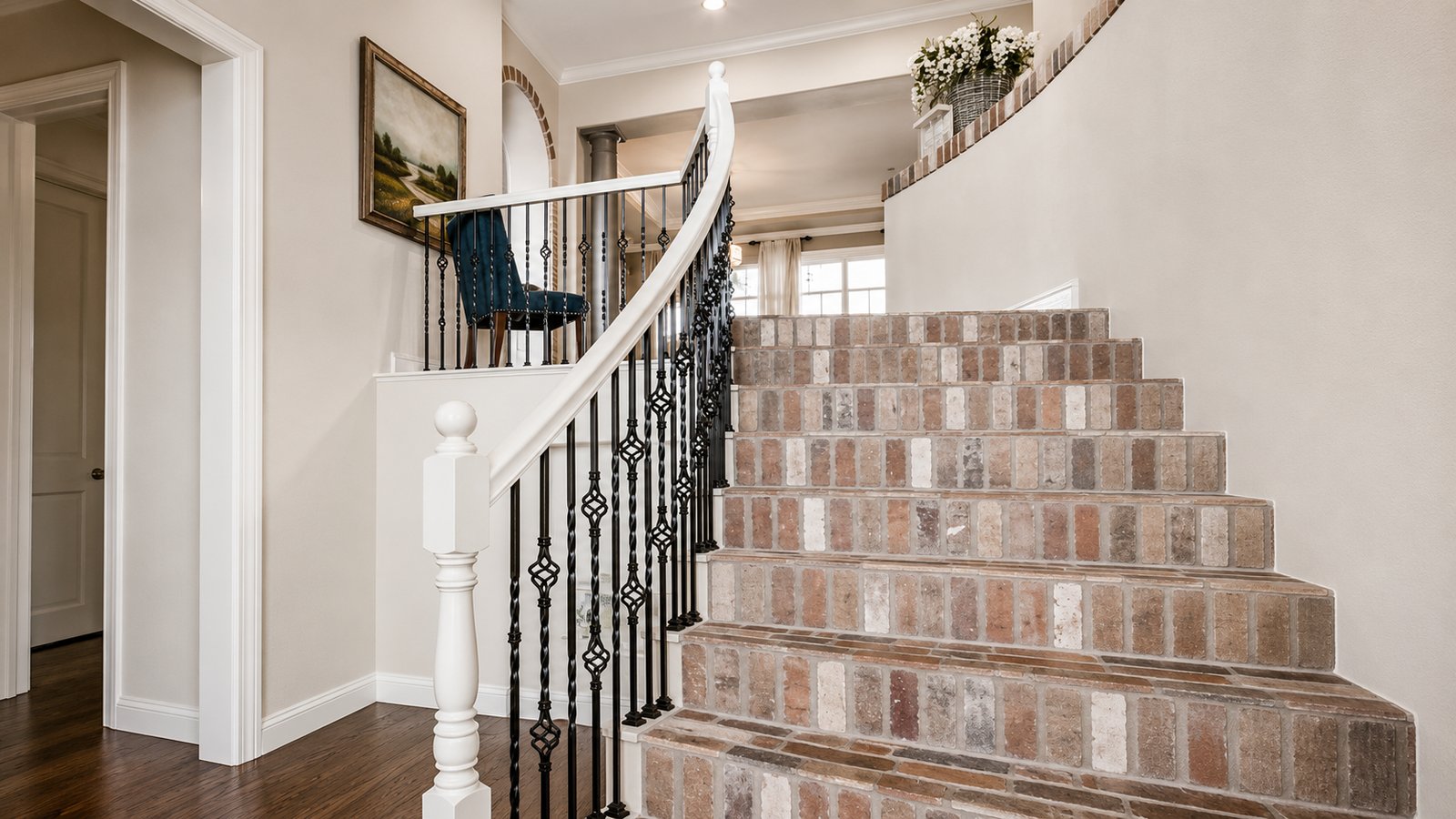 Curved staircase with brick risers and wrought iron balusters