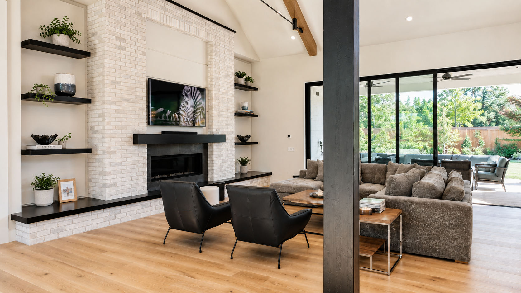 Light-filled living room with brick fireplace and open terrace view